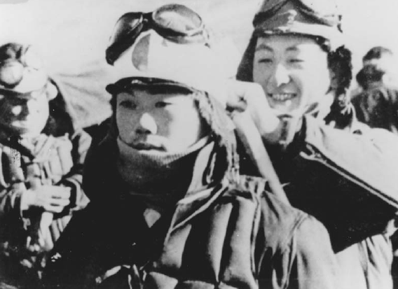Un piloto kamikaze colocando el hachimaki alrededor de la cabeza de su camarada antes de que este emprenda su misión